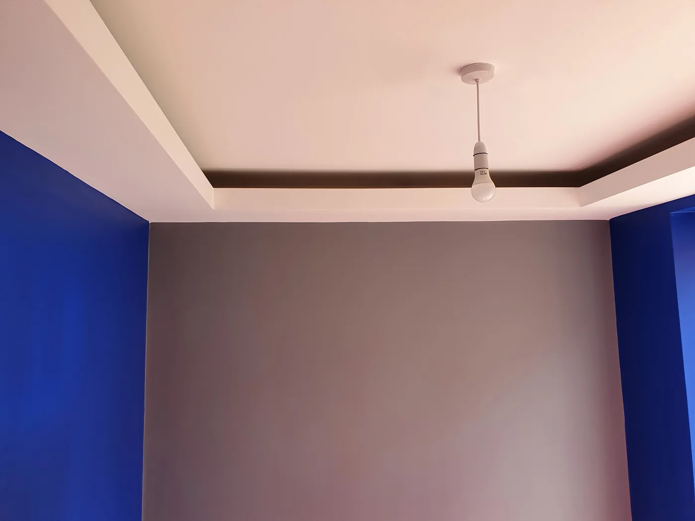 Completed room with smooth painted walls and a crisp ceiling line after damp proofing and replastering